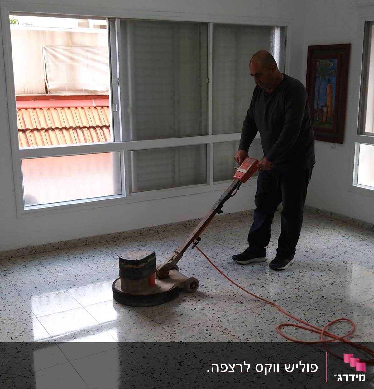 אדם מנקה רצפה עם מכונת פוליש חשמלית